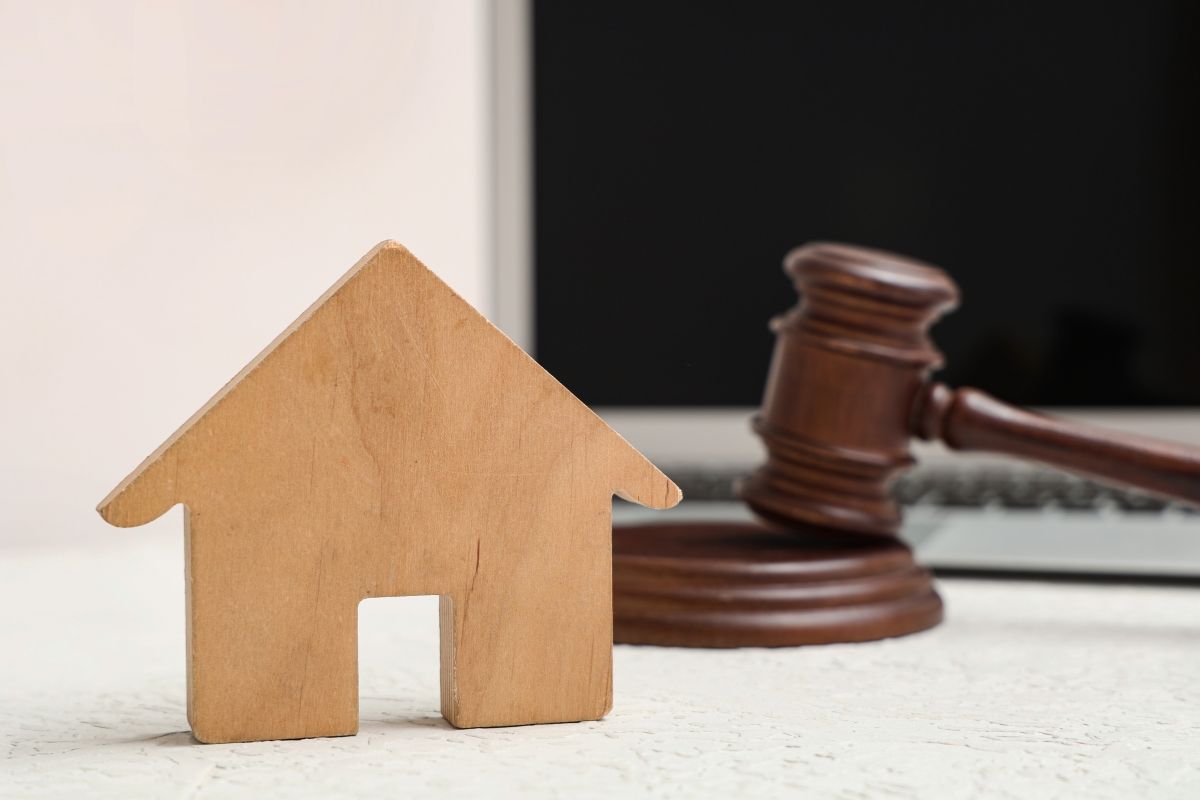 Modello di casa su tavolo bianco, primo piano. Concetto di asta online.